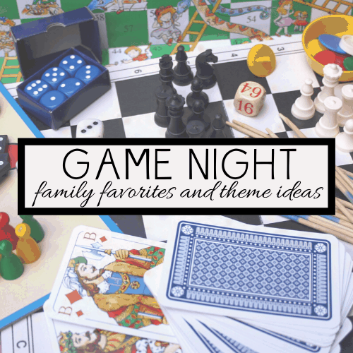 A lively assortment of board game pieces, dice, playing cards, and wooden sticks sprawls across the table. At the center stands a sign with decorative text: Game Night: family favorites and theme ideas, inviting an evening of heartwarming family fun and games.